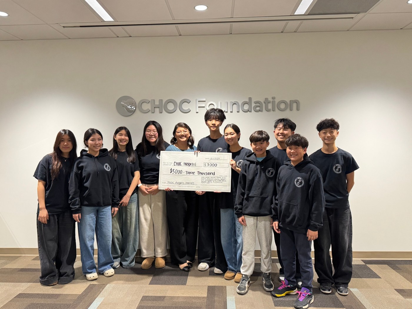Music Angels Hands group at the CHOC Foundation with a $3,000 donation check